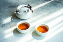Duas xícaras de chá e um bule em uma mesa — Fotografia de Stock