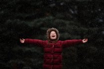 Chica feliz parada al aire libre en la nieve, EE.UU. - foto de stock