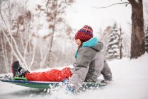 Glückliches Mädchen beim Rodeln im Schnee, Wisconsin, USA — Stockfoto