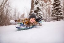 Rapaz sorridente a passear na neve, Wisconsin, EUA — Fotografia de Stock