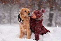 Mädchen im Schnee kuschelt ihren Golden Retriever Hund, Wisconsin, USA — Stockfoto