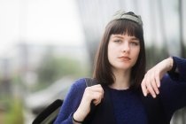 Portrait of a woman standing outdoors leaning against a wall outdoors, Germany — Stock Photo