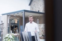 Venditore in piedi in un negozio accanto a campioni di pavimentazione, Germania — Foto stock