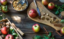 Розташування яблук, волоських горіхів та спецій на дерев'яному столі — стокове фото