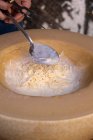 Homem preparando macarrão em uma roda de queijo grana padano — Fotografia de Stock