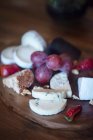Nahaufnahme von Käse und Trauben auf einem Käsebrett — Stockfoto