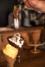 Uomo che gocciola cioccolato fuso su un gelato — Foto stock