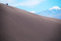 Четыре человека стояли на вершине песчаной дюны в пустыне Атакама близ Арики, Чили — стоковое фото