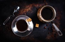 Tasse de café noir avec des cubes de sucre et un cezve — Photo de stock