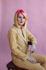 Ritratto di una ragazza cool con i capelli tinti in un abito seduto su una sedia — Foto stock