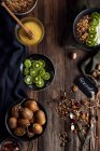 Vista aérea de la granola del desayuno con miel, nueces, yogur y kiwi - foto de stock