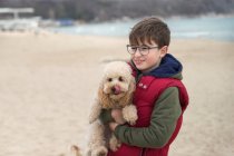 Ragazzo in piedi sulla spiaggia portando il suo cane, Bulgaria — Foto stock