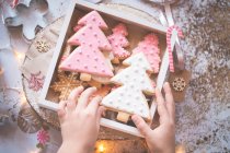 Menino empilhamento casa fez biscoitos de Natal em uma caixa de presente — Fotografia de Stock