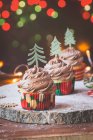 Cupcake con glassa al burro al cioccolato decorati con alberi di Natale — Foto stock