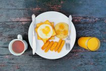 Overhead view of fried breakfast with tea and orange juice — Stock Photo