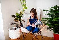 Девушка сидит на стуле и делает домашнее задание — стоковое фото