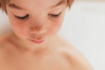 Portrait of a young boy sitting in a bubble bath — Stock Photo