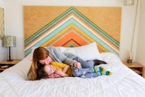 Mère et fille couché ensemble et étreignant sur le lit — Photo de stock