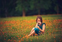 Glückliches Mädchen auf einer Wiese mit lachenden Wildblumen, USA — Stockfoto