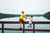 Dois meninos de pé em um cais de pesca, EUA — Fotografia de Stock