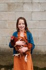 Portrait d'une fille souriante tenant un poulet, États-Unis — Photo de stock