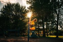 Мальчик качается на качелях в парке, США — стоковое фото