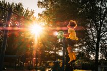 Ragazzo che oscilla su un'altalena in un parco, USA — Foto stock
