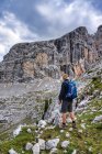 Человек, прогуливающийся в диких клещах, природный парк Фанес-Сеннес-Брейс, Южный Тироль, Италия — стоковое фото