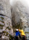Man and woman mountain climbing in the fog, Ebenalp, Switzerland — Stock Photo
