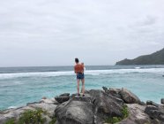 Frau steht mit Baby auf Felsen am Meer, Seychellen — Stockfoto