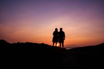 Silhouette eines Paares, das den Sonnenuntergang über dem Meer beobachtet, Maui, Hawaii, USA — Stockfoto