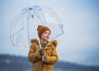 Smiling Boy standing under an umbrella in the rain, Bedford, Halifax, Nova Scotia, Canada — Stock Photo