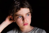 Retrato de un niño reflexivo apoyado en su codo - foto de stock