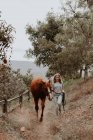 Дівчинка ходить по сільському краєвиді зі своїм конем, штат Каліфорнія, США. — стокове фото