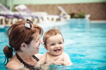 Bonne mère nageant dans une piscine avec son bébé fils, Bulgarie — Photo de stock
