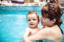 Happy mother swimming in a swimming pool with her baby son, Bulgaria — Stock Photo