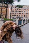 Woman standing in the street tossing her hair, Rome, Lazio, Italy — Stock Photo
