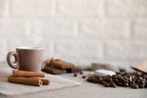 Tasse Kaffee, Proteinriegel, geröstete Kaffeebohnen und Zimtstangen — Stockfoto