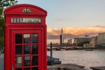 Caja de teléfono roja icónica con el fragmento en la distancia, Londres, Inglaterra, Reino Unido - foto de stock