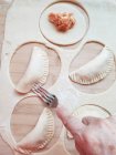 Senior woman making tuna and tomato dumplings — Stock Photo