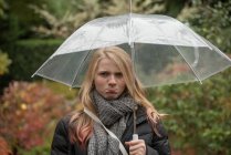 Portrait d'une fille grincheuse debout sous un parapluie, Colombie-Britannique, Canada — Photo de stock