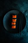 Set di sushi con rotoli di filadelfia servito su tavolo di pietra con bacchette — Foto stock
