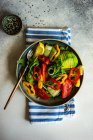 Здоровый овощной салат с арагулой, авокадо и кунжутом на бетонном фоне с копировальным пространством — стоковое фото