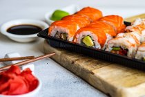 Salmon and prawn maki rolls with pickled ginger, wasabi, soy sauce and chopsticks — Stock Photo