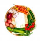 Fresh fruit and vegetables on a circular chopping board — Stock Photo