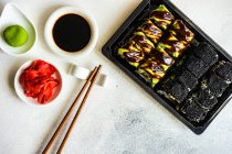 Sushi-Rolle mit Lachs und grünem Gemüse. schwarzer Hintergrund, Draufsicht — Stockfoto