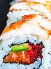 Leckeres Sushi mit Lachs, Philadelphia-Käse, Fisch auf schwarzem Hintergrund, Nahaufnahme — Stockfoto