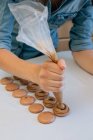 Frau füllt Schokoladenmakronen mit Schokoladenganache — Stockfoto