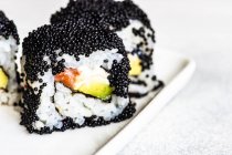 Caviale nero sotto forma di sushi con salmone ed erbe aromatiche — Foto stock