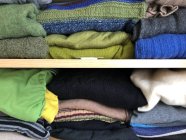 Pila de ropa y ropa sobre un fondo de madera - foto de stock